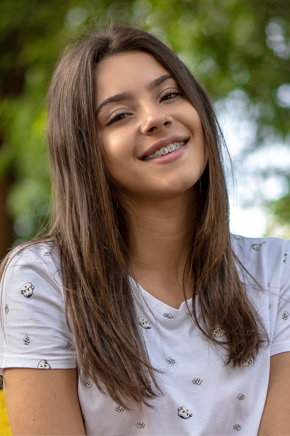 Teen girl smiling while wearing self ligating braces
